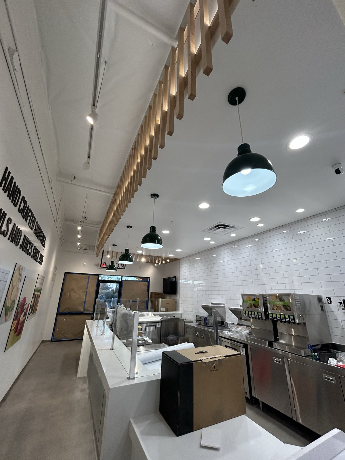 After — finished Juice It Up Tempe interior with wooden slat ceiling feature, green pendant lights, subway tile wall, and equipped service counter