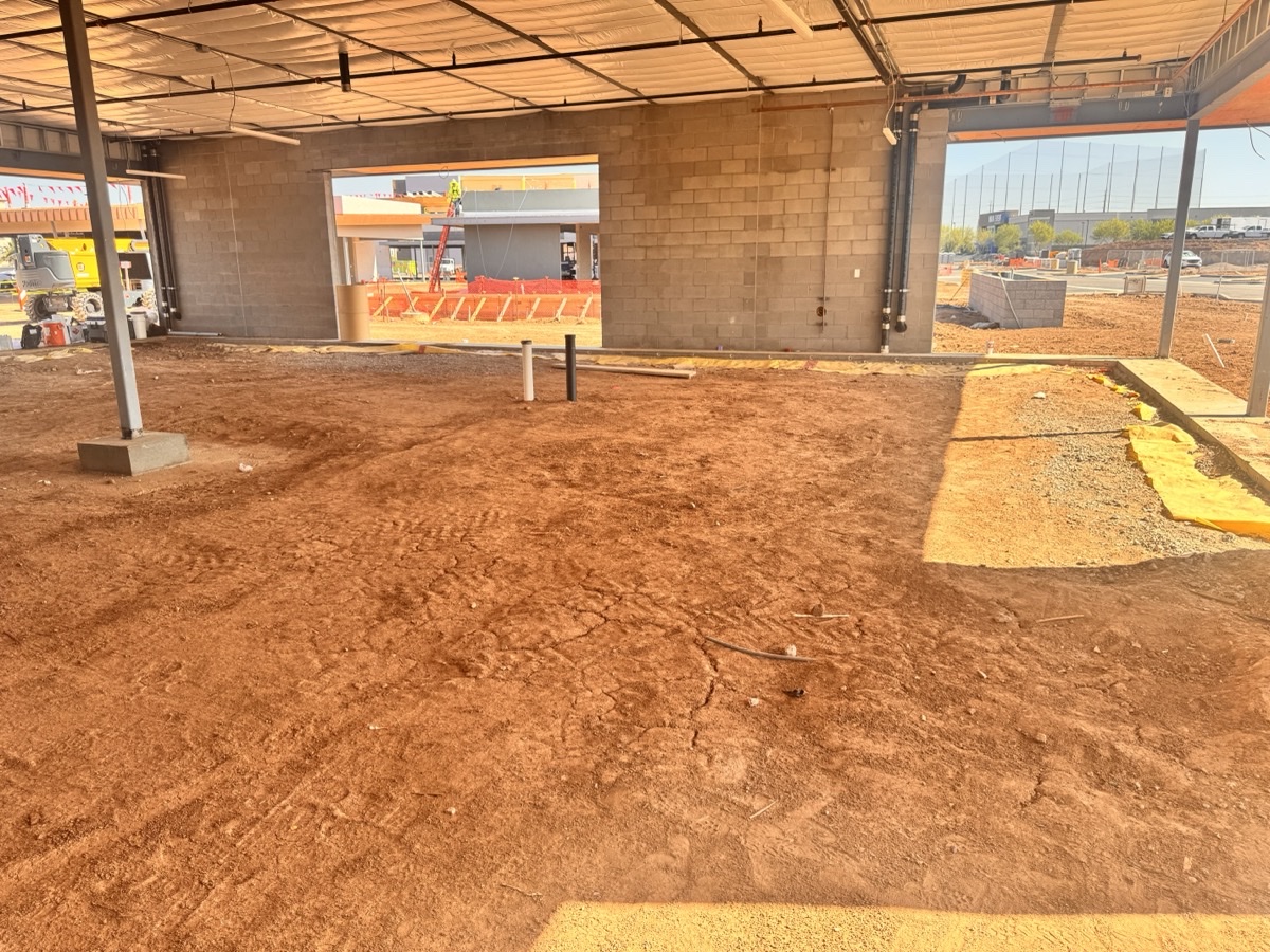 Before — cold dark shell of the future MilkShake Factory in Gilbert, Arizona, with dirt floor and exposed cinderblock walls