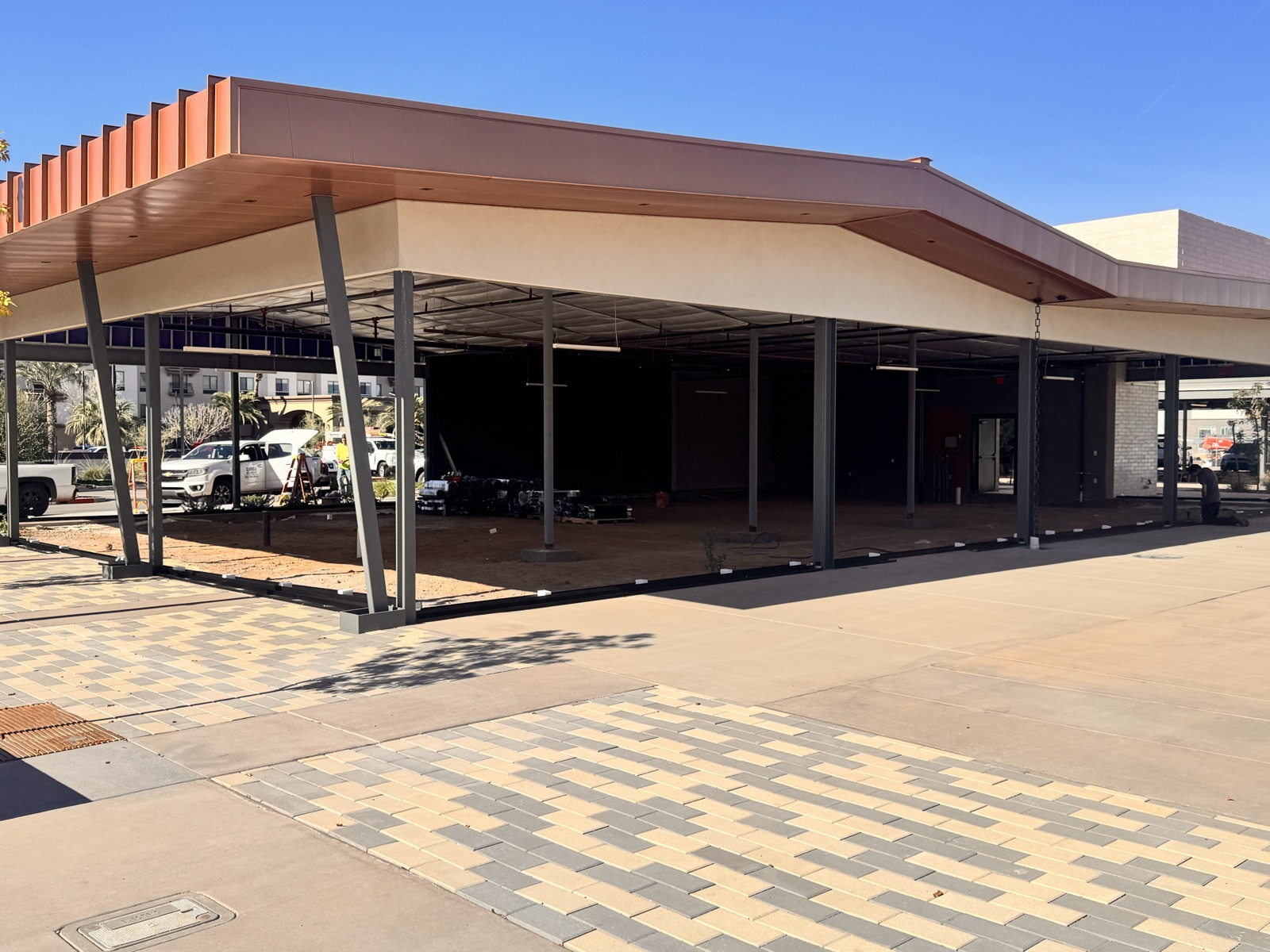 Before — open Northside shell at San Tan Village with steel structure, butterfly canopy framed, and no storefront glazing yet installed